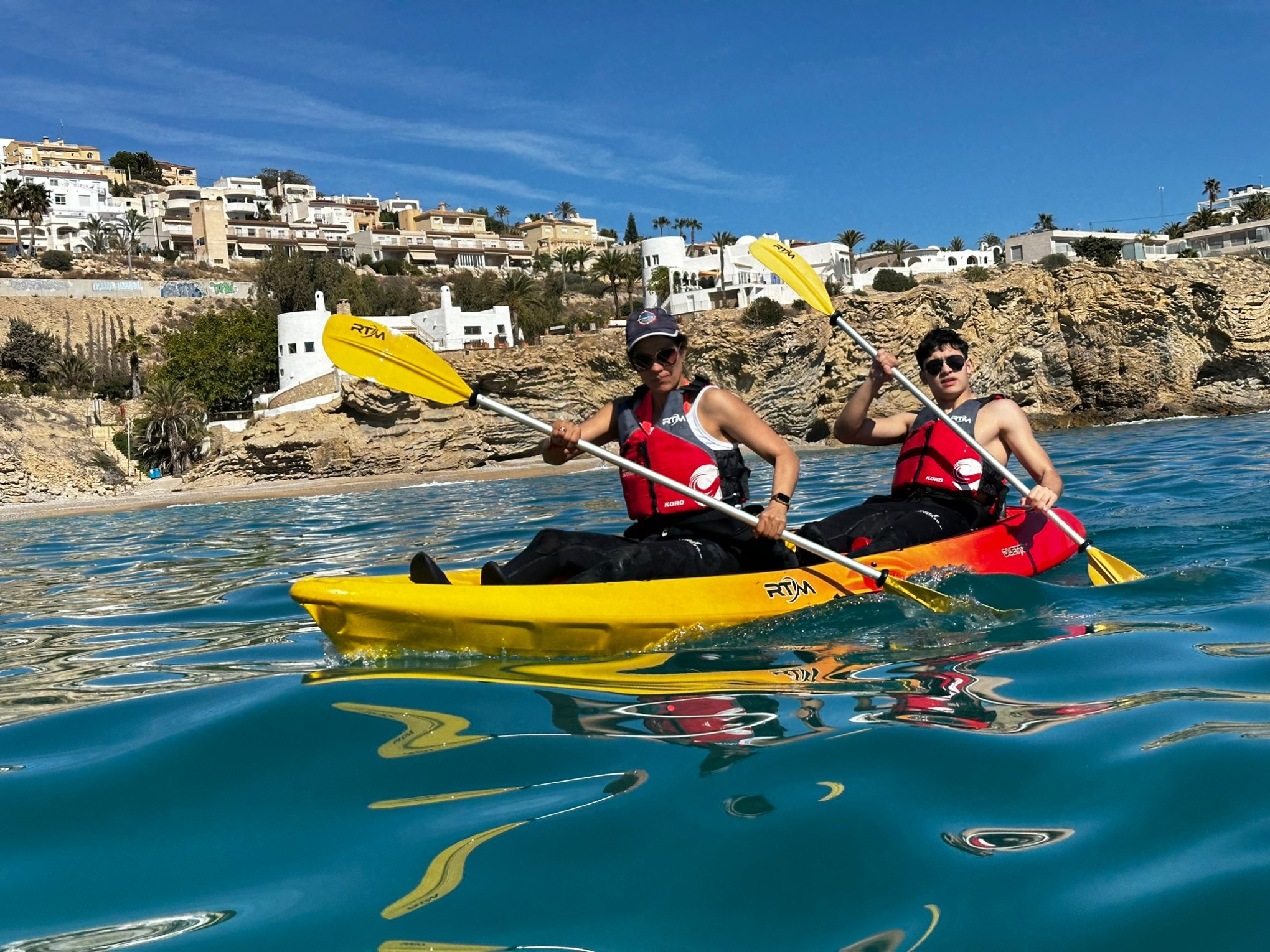 a group of people riding on the back of a boat in the water