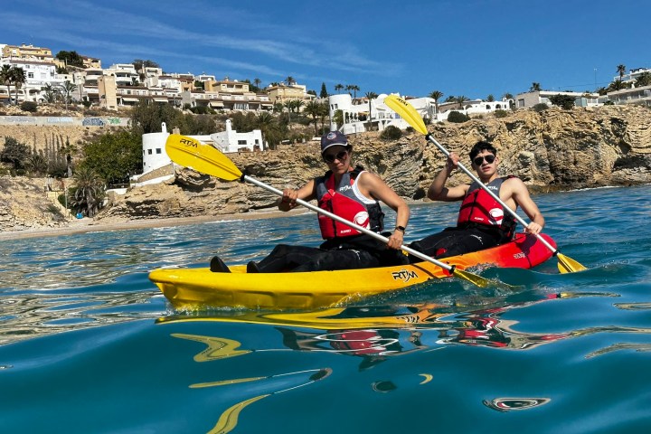 a group of people riding on the back of a boat in the water
