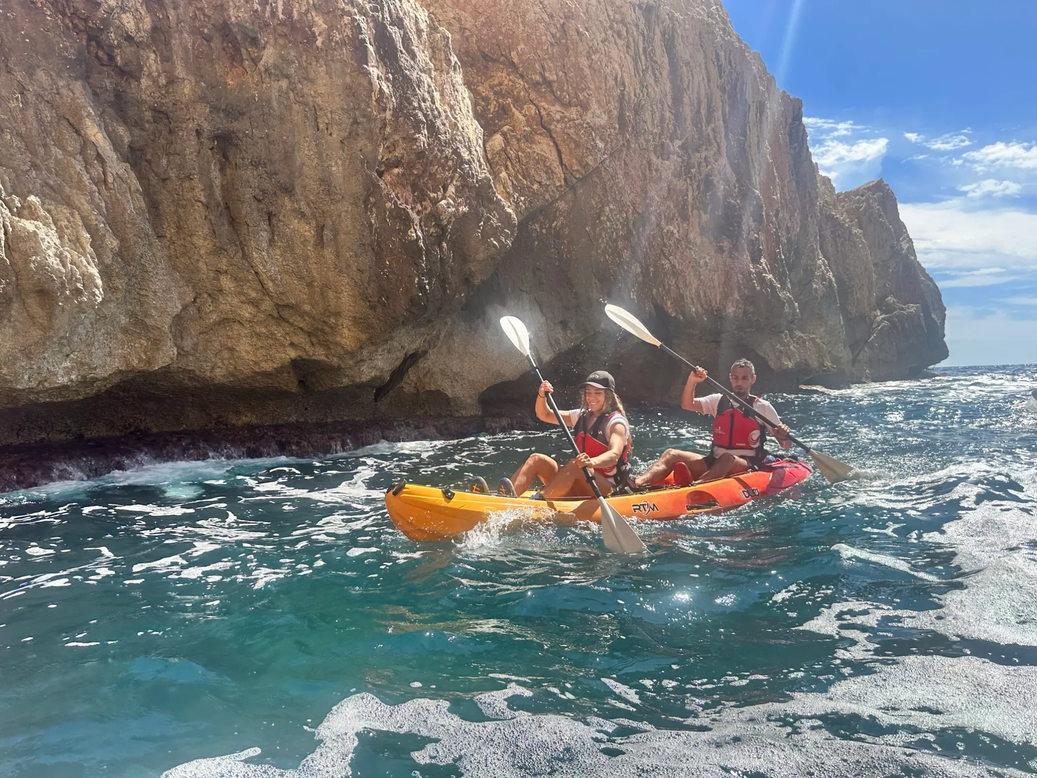 a group of people riding on the back of a boat in the water