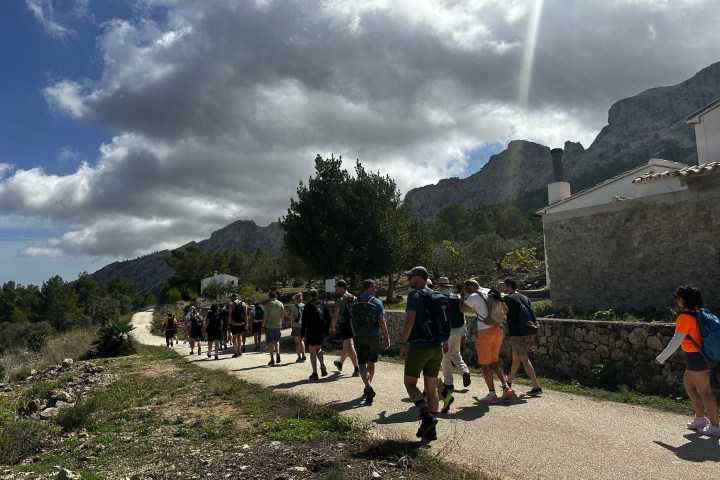 a group of people walking down a dirt road