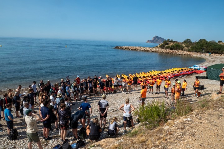 a group of people on a beach near a body of water