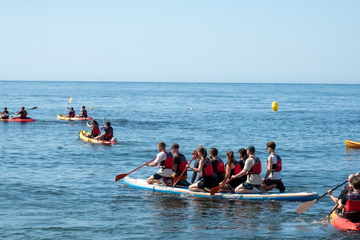 a group of people rowing a boat in the water