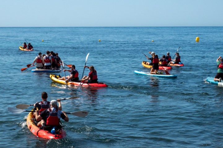 a group of people rowing a boat in the water