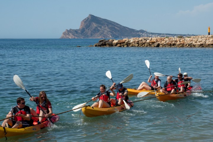 a group of people riding on the back of a boat in the water