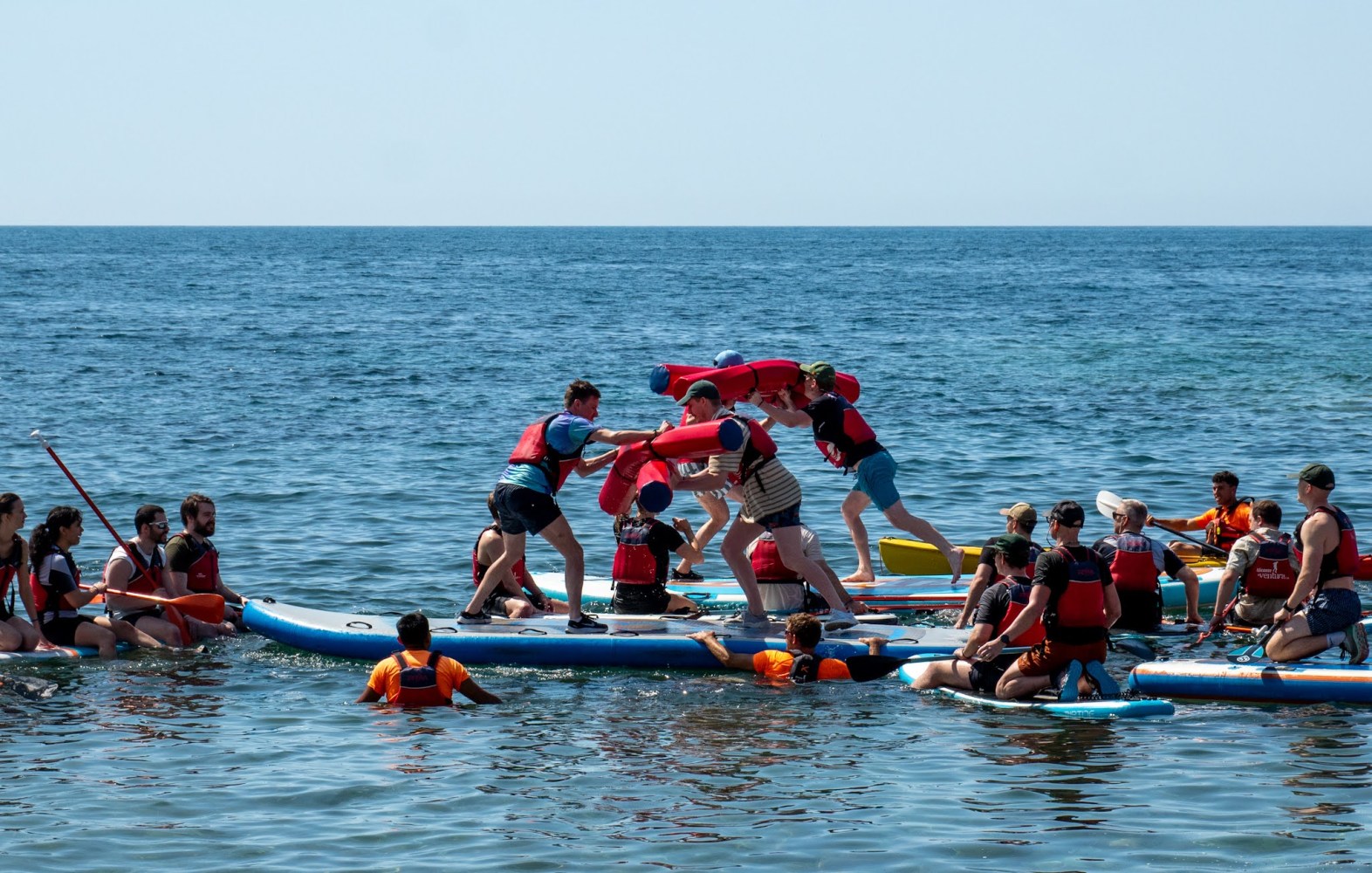 a group of people rowing a boat in the water