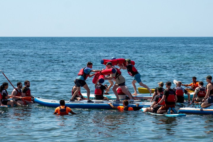 a group of people rowing a boat in the water