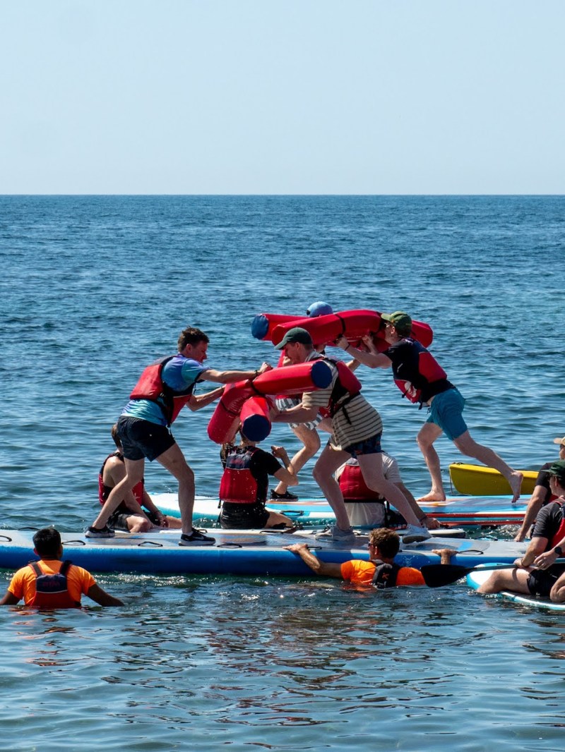 a group of people rowing a boat in the water