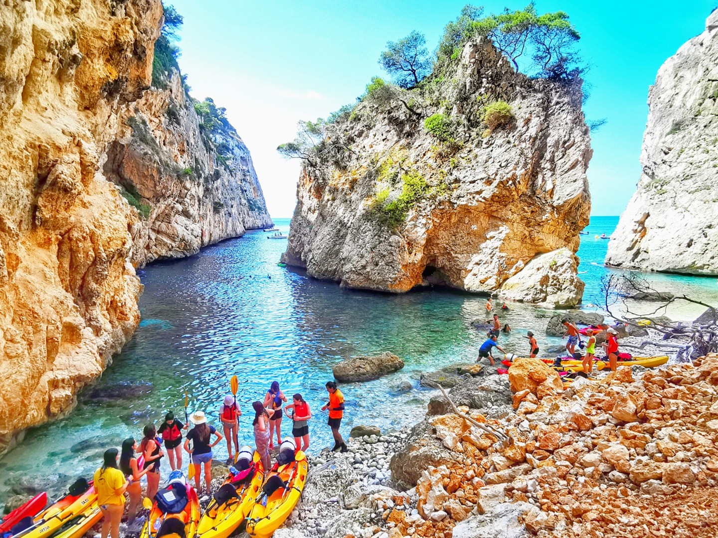 a group of people on a rock next to water