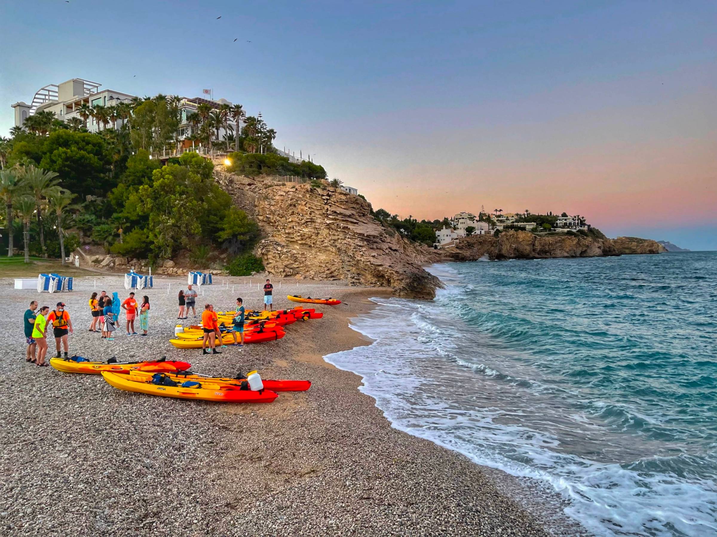 a group of people on a beach near a body of water