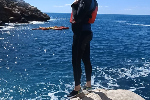 a man standing on a rock next to water