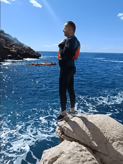 a man standing on a rock next to water