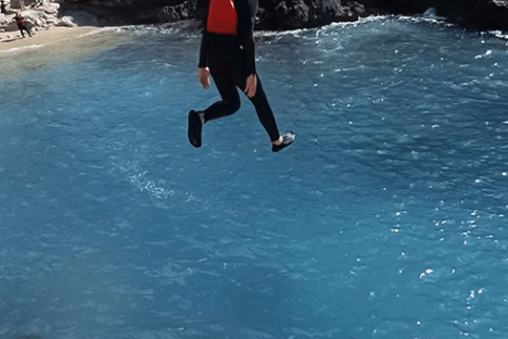 a man riding a surfboard on top of a rock