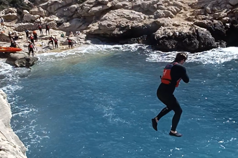 a group of people on a rock in the water