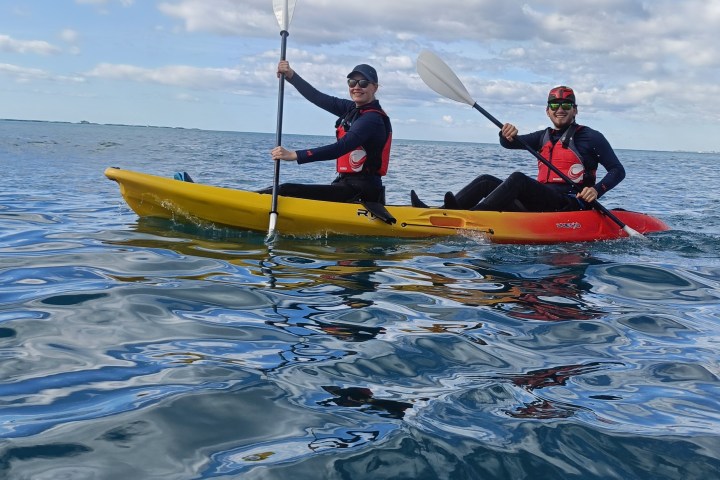 a man riding on the back of a boat in the water
