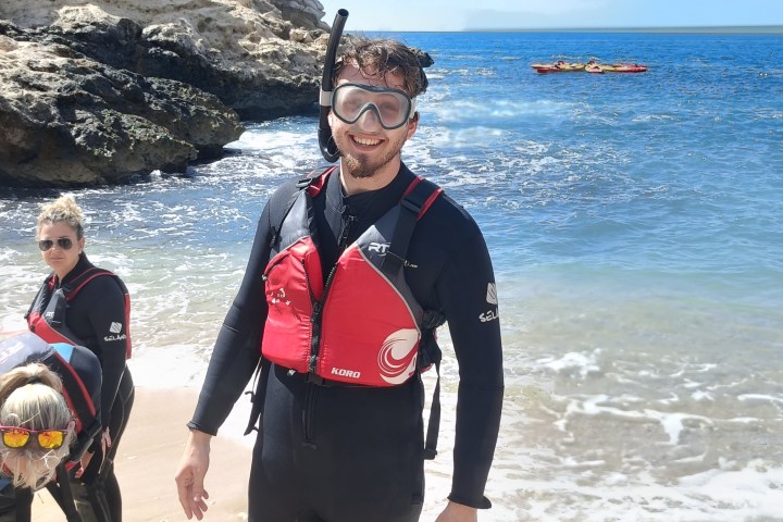 a couple of people on a rocky beach