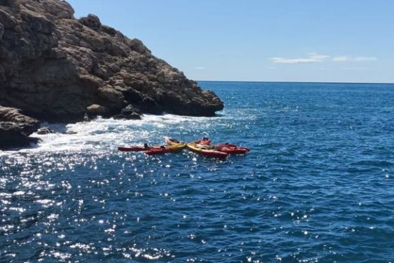 Kayaks flotando junto a una cala durante la ruta hacia la Torre del Aguiló