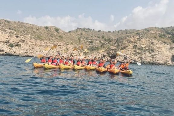 Grupo de participantes navegando en kayak por la costa entre Villajoyosa y Benidorm