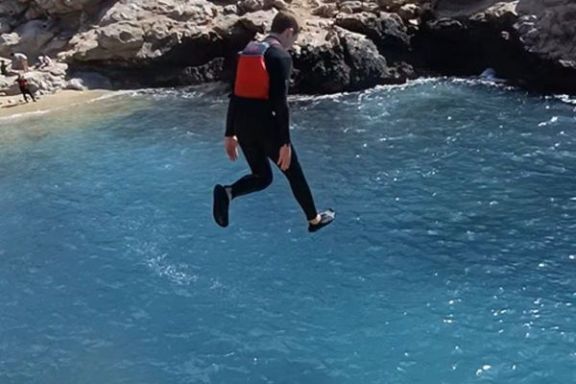 Participante realizando un salto al mar durante la ruta en kayak hasta la Torre del Aguiló