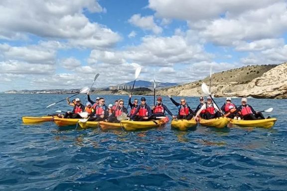 Grupo disfrutando de la ruta en kayak hasta la Torre del Aguiló frente a la costa de Villajoyosa