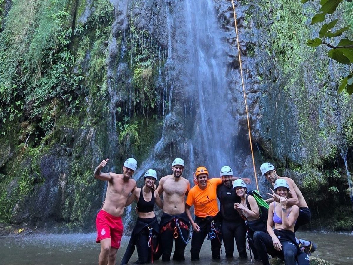a group of people standing next to a waterfall
