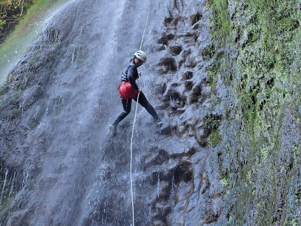 a person standing next to a waterfall