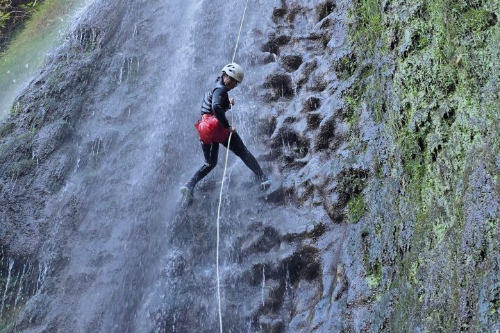a person standing next to a waterfall