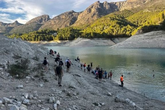 Grupo de senderistas junto al Embalse de Guadalest rodeado de montañas