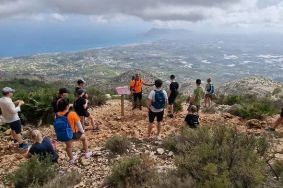 Senderistas contemplando las vistas hacia la costa desde la Sierra de Bèrnia