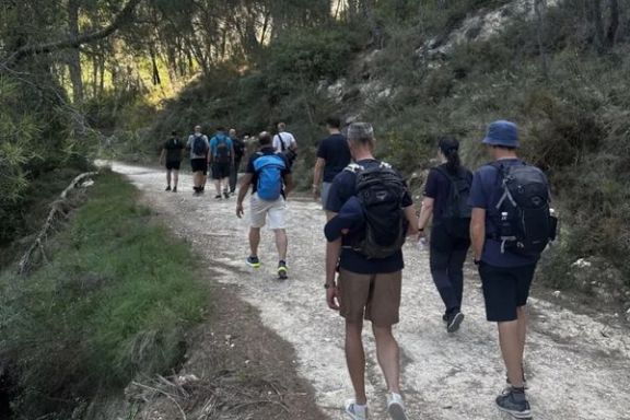 Senderistas recorriendo un camino de montaña durante una ruta guiada en Alicante