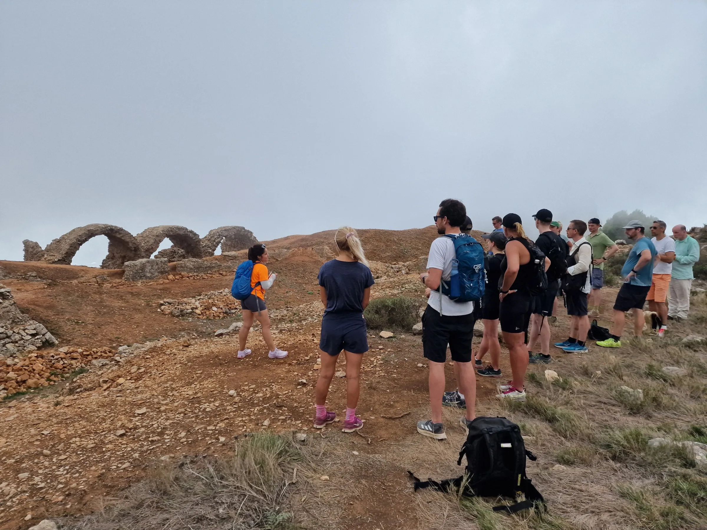 a group of people standing on top of a dirt field