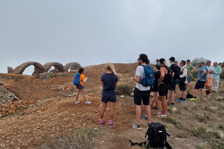 a group of people standing on top of a dirt field