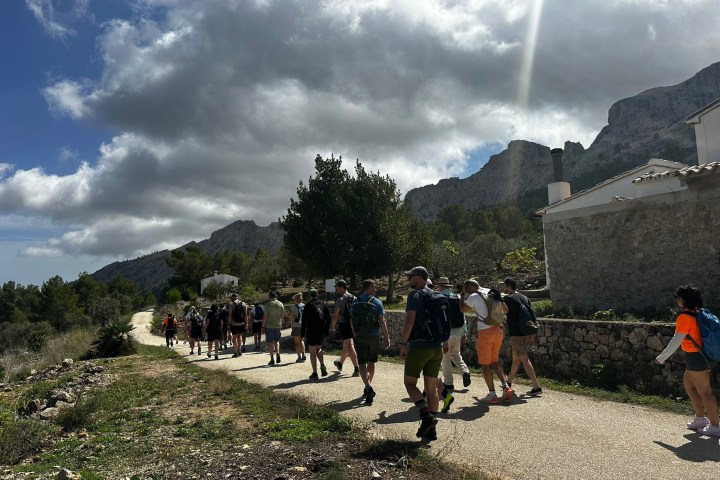 a group of people walking down a dirt road