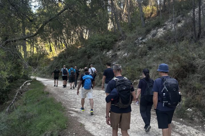 a group of people walking down a dirt road