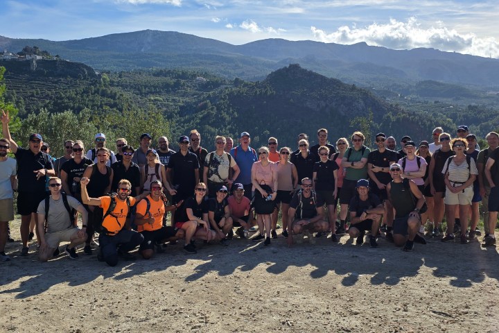 a group of people standing in front of a crowd posing for the camera