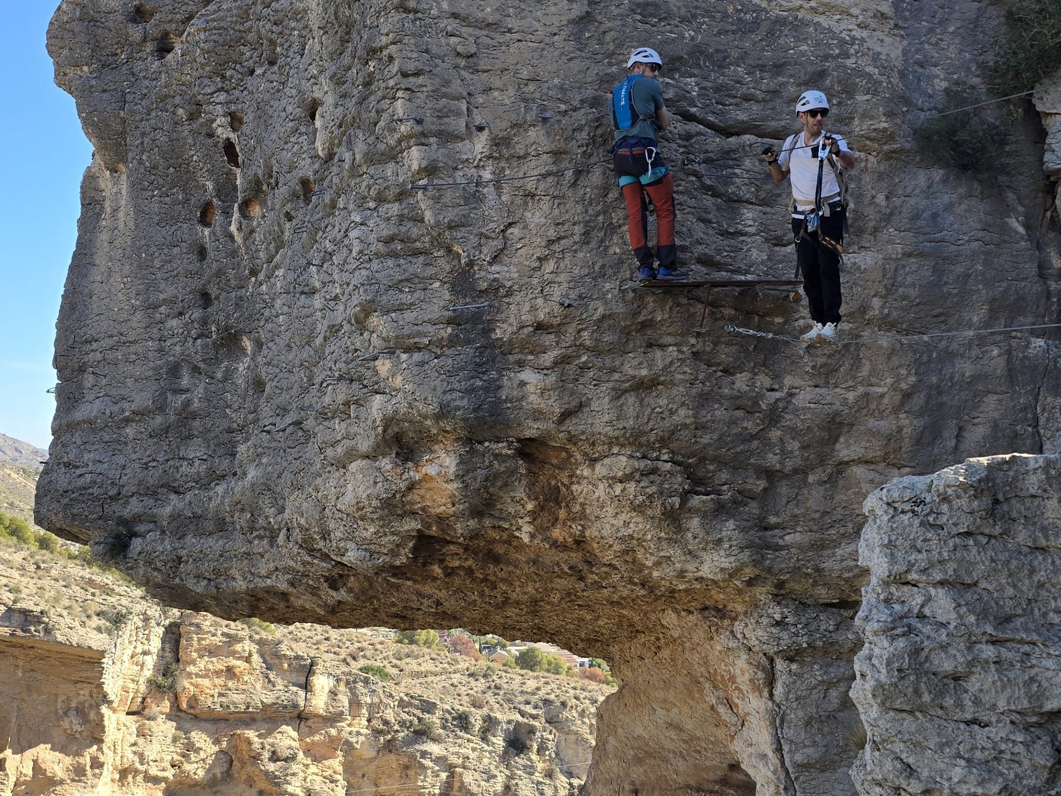 a man standing in front of a large rock