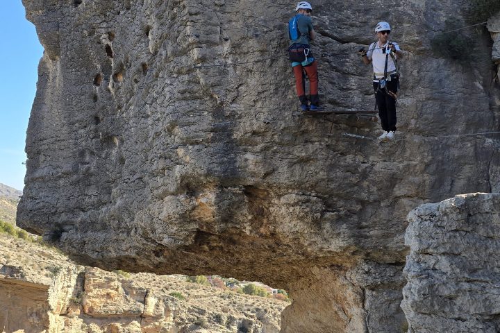 a man standing in front of a large rock