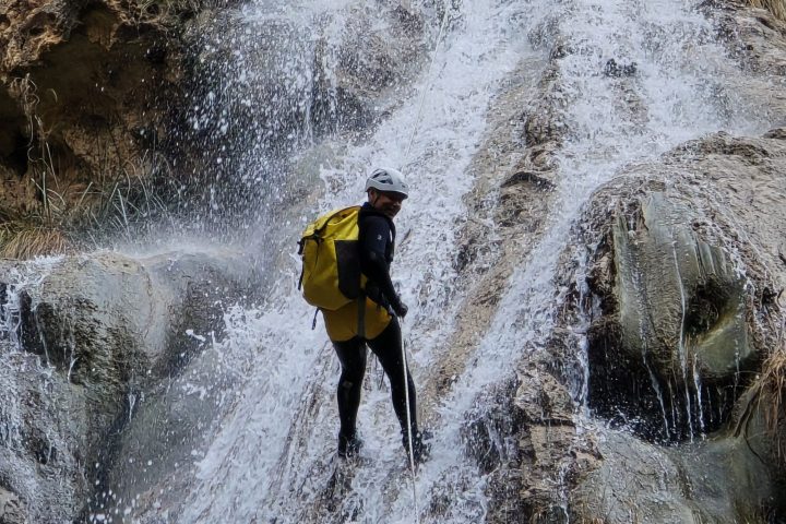 a man standing next to a waterfall