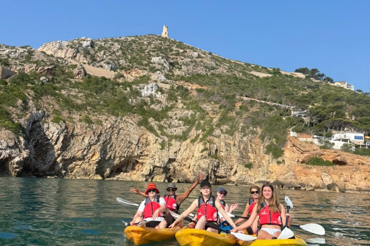 a group of people riding on the back of a boat in the water
