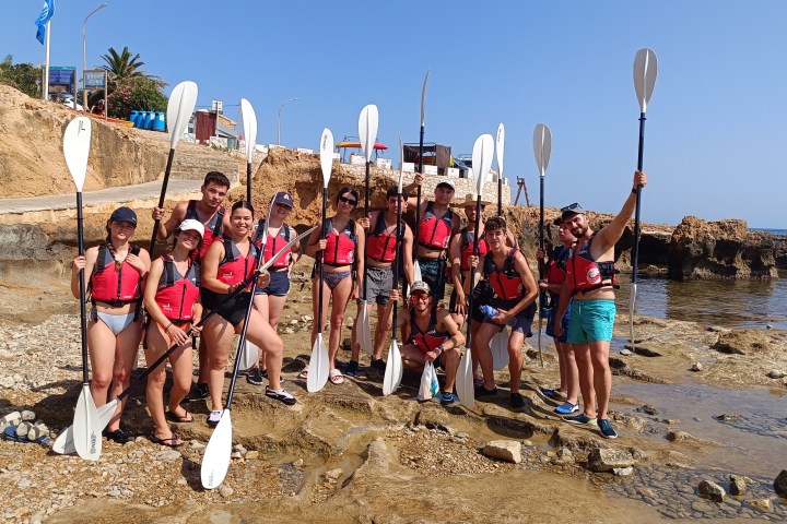 a group of people standing on a beach posing for the camera