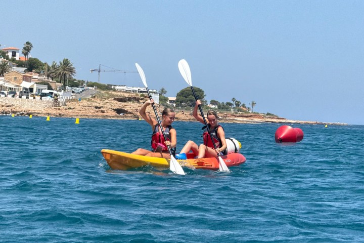 a group of people riding on the back of a boat in the water
