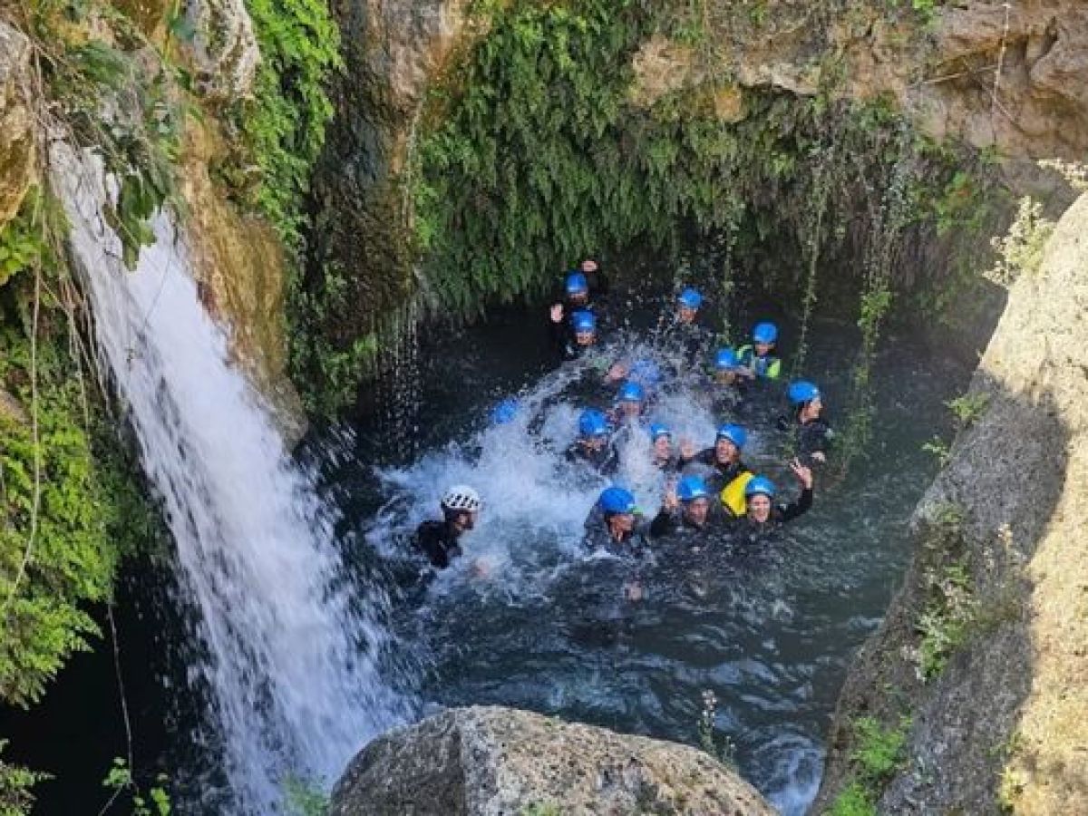 Grupo disfrutando de un barranquismo acuático junto a una cascada con Alicante Aventura
