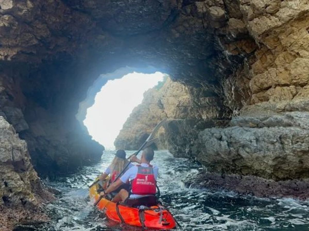 Kayaks entrando en el interior de la Cova Tallada durante una excursión con Alicante Aventura