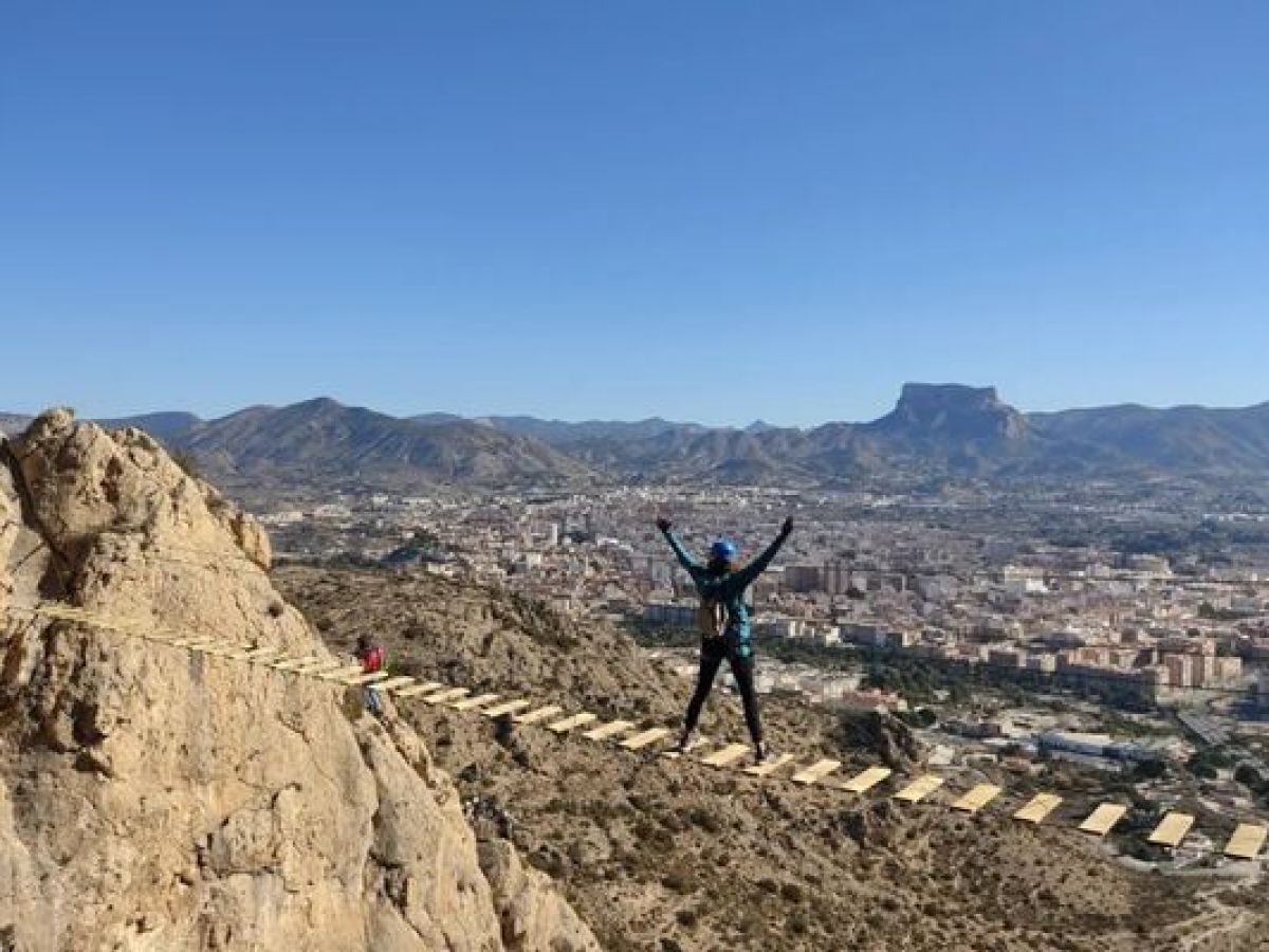 Participante cruzando un puente tibetano en una vía ferrata sobre Alcoy