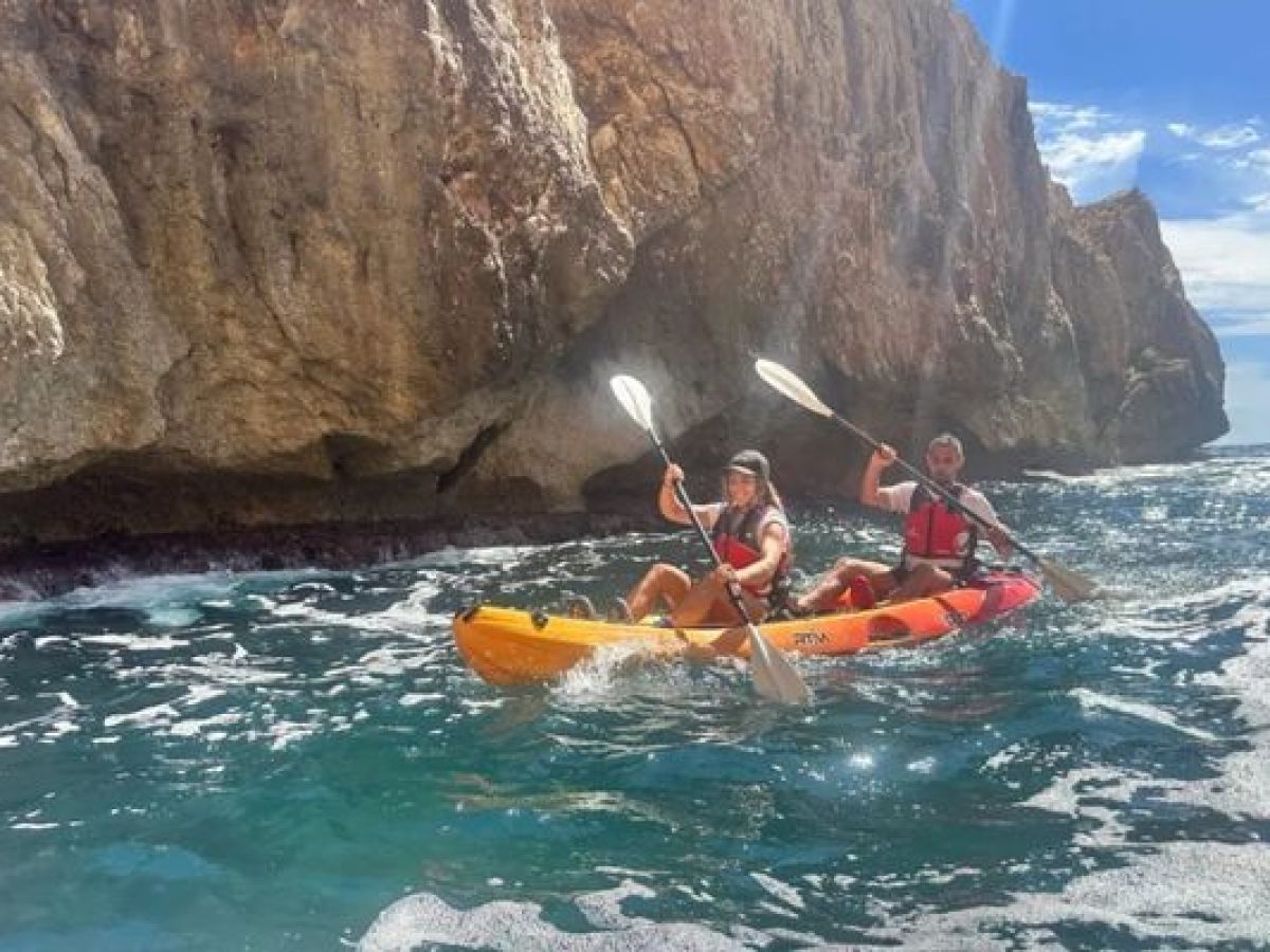 Pareja navegando en kayak junto a los acantilados de la costa de Alicante
