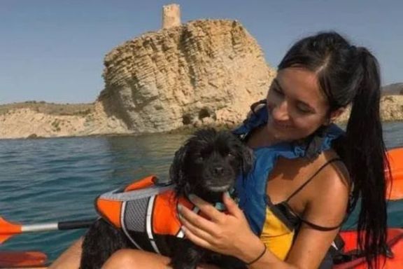 Participante con su perro en kayak frente a la Torre del Xarco en Villajoyosa