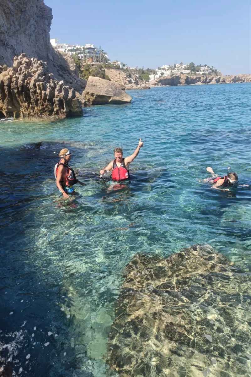 Participantes practicando snorkel en una cala de aguas cristalinas durante la ruta en kayak por las calas de Villajoyosa