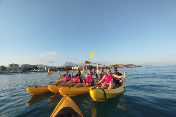 Grupo disfrutando de la ruta en kayak al atardecer frente a la costa de Villajoyosa