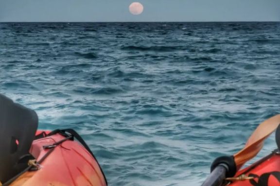 Vista desde un kayak con la luna reflejándose sobre el mar en Villajoyosa