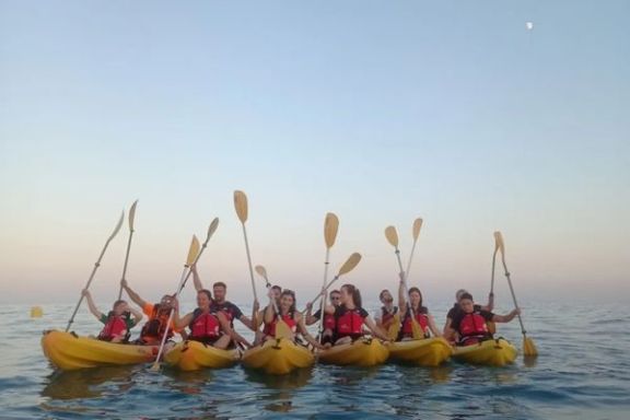 Grupo de participantes durante la ruta nocturna en kayak al atardecer