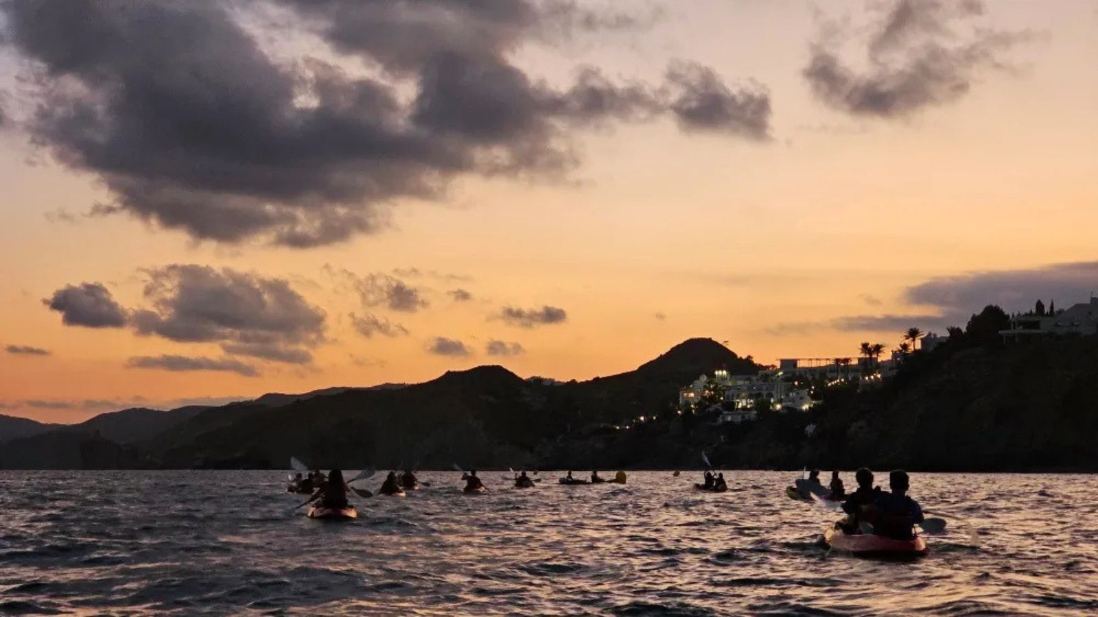 Participantes navegando al atardecer durante la ruta nocturna en kayak por la costa de Villajoyosa